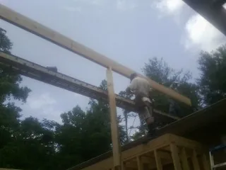 Carpenter setting a ridge beam over a new addition frame — Ice Dam Removal by Roofing Brothers in Beacon Falls