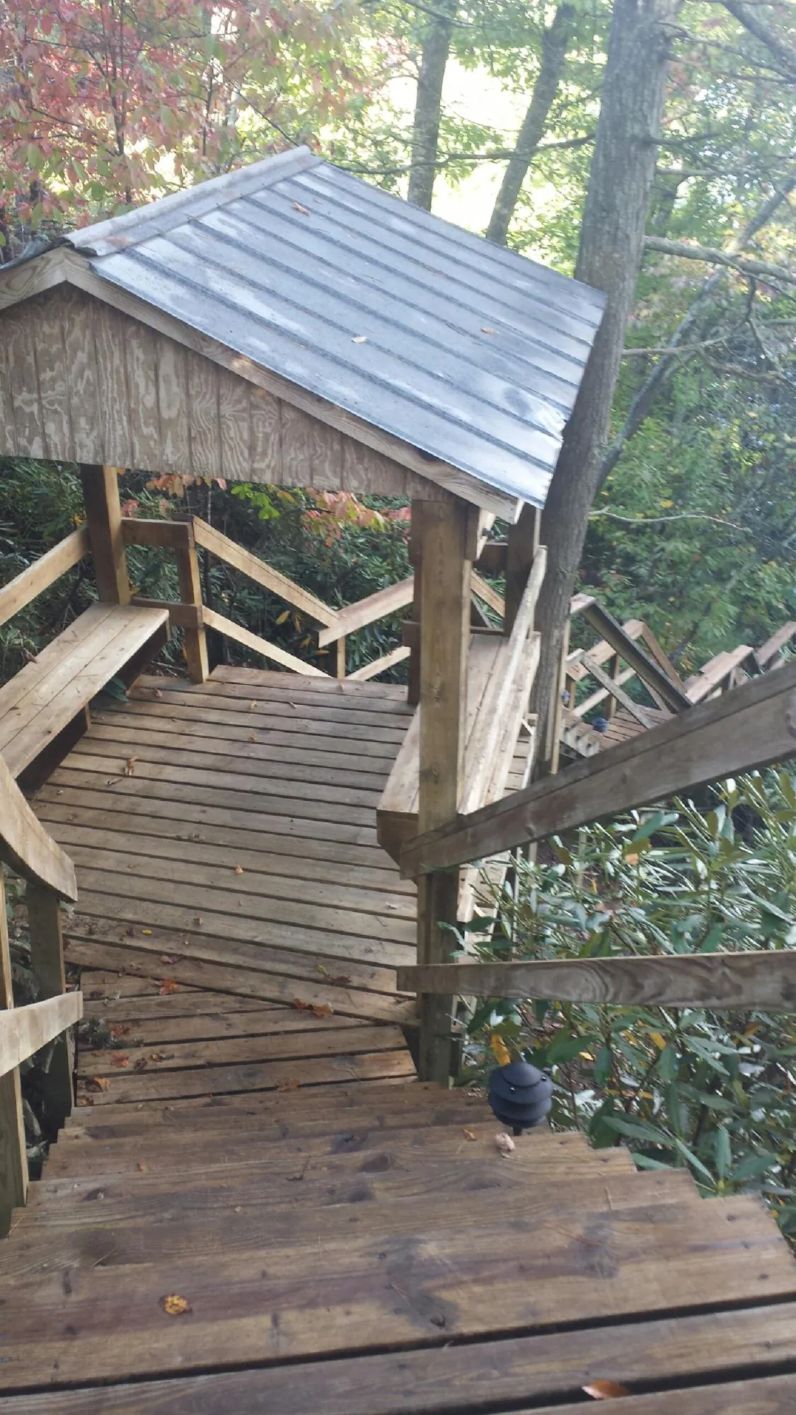 Metal roofed shelter over wooden steps on a wooded walkway — Skylight Repair & Installation work by our crew in Beacon Falls