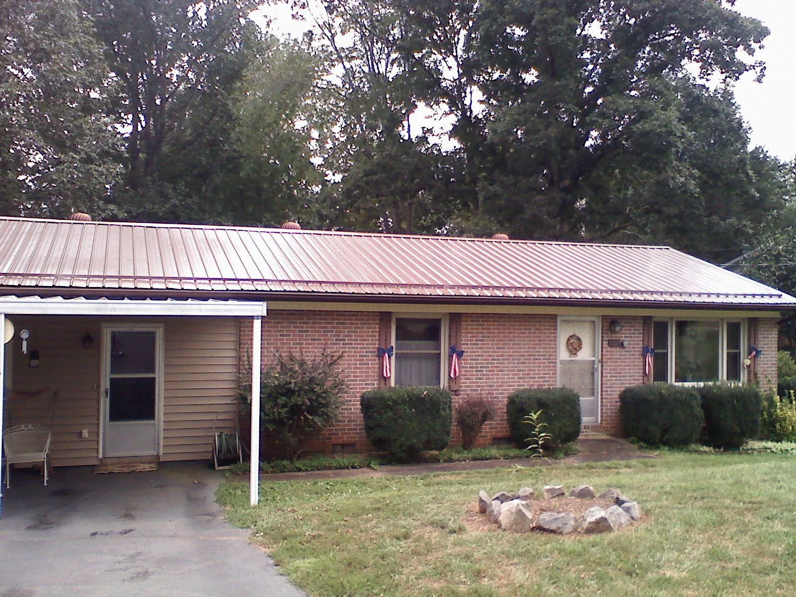 Bronze metal roof and carport on a brick ranch home — Roof Repair work by our crew in Beacon Falls